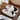 Pair of white slippers with dog design on a wooden surface.