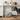 Dog standing next to a storage basket with dog pattern in a home setting.