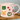 Mug with Christmas-themed illustrations including a bear, deer, wreath, and presents on a light pink background.
