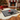 Christmas-themed doormat with paw print and Santa hat design on a festive living room floor.