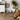 Dog lying on a rug with bowls and a toy in a room with a plant and a sign reading 'Sophie'.