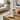 A white ceramic dish shaped like a dog, featuring a black line art sketch of a dog, styled on a light wood side table in a bright, modern living room.