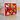 Red towel with dog patterns held by a hand on a kitchen counter.