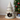 Cat tree shaped like a Christmas tree with colorful pom-poms next to a decorated Christmas tree.