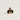A small enamel pin shaped like a black and tan dachshund wearing a red Santa hat with rhinestones, photographed on a plain light beige background.