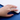 Hand wearing a silver ring with a diamond on a blue surface