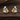 Pair of silver and gold earrings on a wooden surface