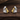 Pair of silver and gold earrings on a wooden surface