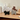 Dog-shaped felt items on a wooden surface with a bottle in the background
