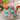 Colorful birthday cake with animal-themed candles in a festive setting with balloons and gifts.
