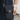 Black crossbody bag with a paw print design held by a person.