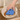 Person using a blue sponge with a dog design to clean a greasy pan.