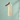 A tall champagne flute filled with bubbly champagne, set against a soft mint green background with a small brown dachshund figurine balancing on the rim of the glass.