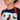 Person wearing a colorful apron with dog illustrations on a pink background