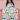 Person wearing a colorful apron with dog patterns on a pink background
